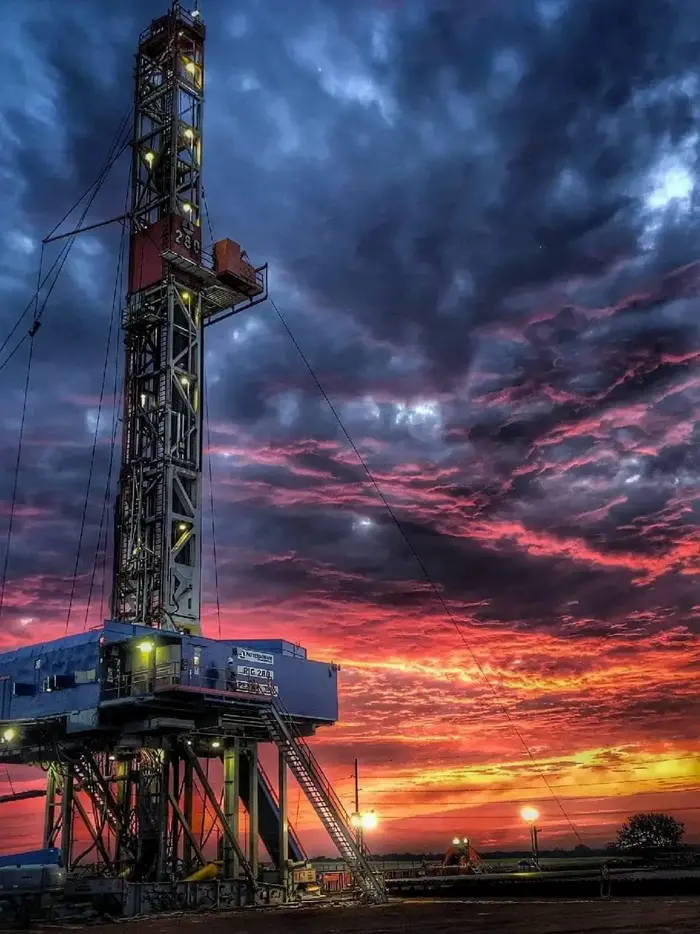 Drilling rig lit against an evening sky in West Texas
